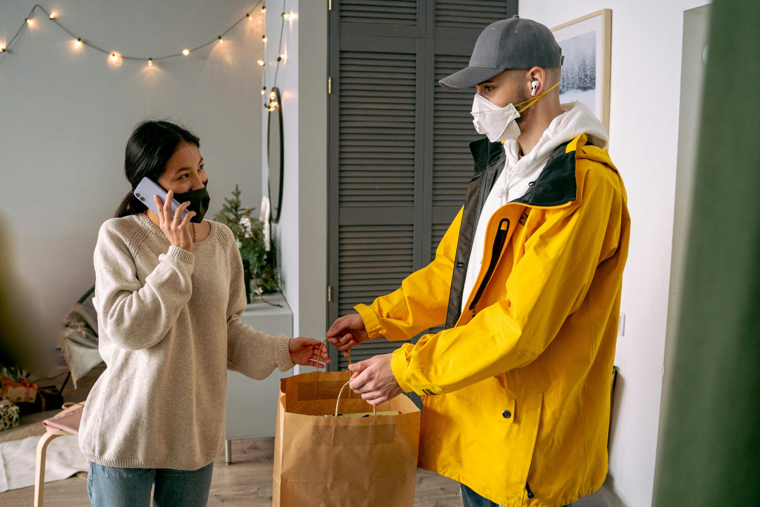A woman receives a delivery in a contactless manner, showcasing modern safety practices.